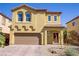 Two-story home showcasing a well-maintained front yard and a two-car garage with a brick-paved driveway at 320 Point Loma Ave, North Las Vegas, NV 89031