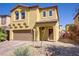 Two-story home showcasing a well-maintained front yard and a two-car garage with a brick-paved driveway at 320 Point Loma Ave, North Las Vegas, NV 89031