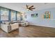 Spacious living room with a large sectional couch, wood-look floors, and vibrant artwork at 320 Point Loma Ave, North Las Vegas, NV 89031