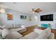 Spacious living room featuring light blue walls, wood-look floors, modern lighting, and a comfortable sectional sofa at 320 Point Loma Ave, North Las Vegas, NV 89031