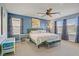 Main bedroom with bright blue accent wall, carpet, many windows for natural light, and curtains at 320 Point Loma Ave, North Las Vegas, NV 89031