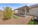 A cozy backyard patio with an overhang, complemented by brick pavers, potted plants, and desert landscaping at 605 Cadence Vista Dr, Henderson, NV 89011