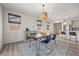 Cozy dining room features a wood table, blue chairs, and a modern chandelier at 605 Cadence Vista Dr, Henderson, NV 89011