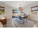 Bright dining area with modern table, blue chairs, and a decorative chandelier at 605 Cadence Vista Dr, Henderson, NV 89011