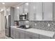Gourmet kitchen featuring stainless steel appliances, quartz countertops, and stylish gray cabinetry at 605 Cadence Vista Dr, Henderson, NV 89011