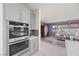 Modern kitchen with built-in double ovens and stainless steel appliances, seamlessly connecting to the living area at 605 Cadence Vista Dr, Henderson, NV 89011