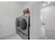Modern laundry room with side-by-side washer and dryer units and tiled floor at 605 Cadence Vista Dr, Henderson, NV 89011