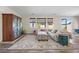 Spacious living room featuring a comfortable sectional sofa, large windows, and stylish decor at 605 Cadence Vista Dr, Henderson, NV 89011