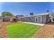 Private backyard with a patch of grass, concrete patio, storage shed, and desert landscaping at 6770 Laronda Ln, Las Vegas, NV 89156