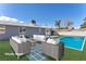 Staged backyard showcasing an outdoor seating area and a swimming pool for relaxation and entertainment at 6770 Laronda Ln, Las Vegas, NV 89156
