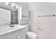 Well-lit bathroom featuring a white vanity, toilet, and shower with gray tile surround at 6770 Laronda Ln, Las Vegas, NV 89156