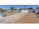Home exterior view featuring a fenced yard, a two-car garage, and desert-style landscaping at 6770 Laronda Ln, Las Vegas, NV 89156