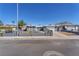 Street view of single-story home featuring desert landscaping, secure fencing, and a two-car garage at 6770 Laronda Ln, Las Vegas, NV 89156