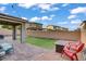 Backyard featuring patio, fire pit, artificial grass, and lounge chairs at 10290 Lodge Pine Ave, Las Vegas, NV 89166