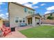 An inviting backyard with a covered patio, artificial grass, and comfortable seating area with two red Adirondack chairs at 10290 Lodge Pine Ave, Las Vegas, NV 89166