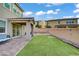 Spacious backyard featuring a covered patio, artificial grass, rock landscaping, and relaxing hammock area at 10290 Lodge Pine Ave, Las Vegas, NV 89166