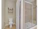 Bathroom featuring toilet, shower with glass door, tile flooring, and neutral color palette at 10290 Lodge Pine Ave, Las Vegas, NV 89166