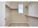 Walk-in closet with shelves, carpet, and a window for natural light at 10290 Lodge Pine Ave, Las Vegas, NV 89166