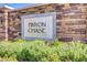 Close up of the community sign, made of stone, surrounded by lush foliage at 10290 Lodge Pine Ave, Las Vegas, NV 89166