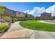 Enjoy scenic community green space featuring a sidewalk, bench, mature trees and lush flowering bushes at 10290 Lodge Pine Ave, Las Vegas, NV 89166