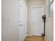Hallway with wooden floors and neutral paint features two doors, a light switch, and a vacuum cleaner at 10290 Lodge Pine Ave, Las Vegas, NV 89166
