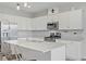 Modern kitchen with stainless steel refrigerator, white cabinets, and a central island for dining at 10290 Lodge Pine Ave, Las Vegas, NV 89166