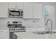 Close-up of modern kitchen with stainless steel appliances and white countertops and cabinets at 10290 Lodge Pine Ave, Las Vegas, NV 89166
