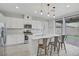 Modern white kitchen with stainless steel appliances and a kitchen island with barstool seating at 10290 Lodge Pine Ave, Las Vegas, NV 89166