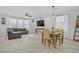Open concept living area with a dark couch, wood floors, a dining room, and natural lighting at 10290 Lodge Pine Ave, Las Vegas, NV 89166