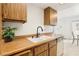 Kitchen features wood cabinets, stainless steel sink, and bright lighting at 1101 Willow Tree Dr # D, Las Vegas, NV 89128