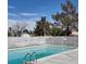 A community swimming pool with a white fence, surrounded by mature trees and clear blue skies at 1101 Willow Tree Dr # D, Las Vegas, NV 89128
