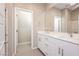 Bathroom featuring double sinks, white cabinets, a large mirror, and a walk-in shower at 11236 Rainbow Peak Ave # 210, Las Vegas, NV 89135