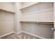 Bright walk-in closet featuring multiple wooden shelving racks and neutral carpet at 11236 Rainbow Peak Ave # 210, Las Vegas, NV 89135