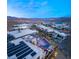 Twilight aerial view of a modern home with solar panels, a pool, and a lake view in a gated community at 12 Falling Canyon Ct, Henderson, NV 89011