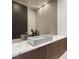Modern powder room with stylish sink, marble countertop, textured wall and dark wood cabinetry at 12 Falling Canyon Ct, Henderson, NV 89011
