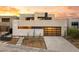 Modern home with a sleek design, desert landscaping, and eye-catching golden garage door at 12 Falling Canyon Ct, Henderson, NV 89011