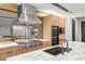 Modern kitchen features a cooktop, double ovens, stainless steel hood, marble countertops and ample cabinetry at 12 Falling Canyon Ct, Henderson, NV 89011