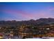 Scenic view of a neighborhood nestled against a mountain range, reflecting the warm glow of twilight at 12 Falling Canyon Ct, Henderson, NV 89011