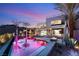 Stunning modern home with a sleek pool, elegant palm trees, and a cozy outdoor fire pit under the twilight sky at 12 Falling Canyon Ct, Henderson, NV 89011