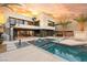 Stunning backyard oasis featuring a sleek pool, spa, outdoor kitchen, and a modern home design at 12 Falling Canyon Ct, Henderson, NV 89011