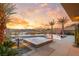 Beautiful backyard pool area with palm trees, a luxurious fire pit, and desert landscape, perfect for outdoor relaxation at 12 Falling Canyon Ct, Henderson, NV 89011