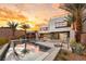 Modern home showcasing a luxurious pool, fire pit, and outdoor living space with picturesque sunset views at 12 Falling Canyon Ct, Henderson, NV 89011