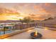 Scenic rooftop deck showcasing a cozy fire pit and stunning views of the desert landscape, lake, and sunset at 12 Falling Canyon Ct, Henderson, NV 89011