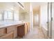 Bright bathroom featuring dual sinks and tub/shower combo with glass door at 1212 Equator Ave, North Las Vegas, NV 89032