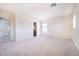 Spacious carpeted bedroom with an archway entrance to another room and bright natural light at 1212 Equator Ave, North Las Vegas, NV 89032