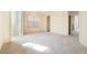 Bright, carpeted living room with arched doorway and natural light from the window at 1212 Equator Ave, North Las Vegas, NV 89032