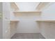 An empty walk-in closet with wooden shelving and carpet at 1212 Equator Ave, North Las Vegas, NV 89032