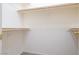 A bright, empty walk-in closet with wooden shelving and carpet at 1212 Equator Ave, North Las Vegas, NV 89032
