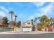 Inviting two-story home with a tile roof, two-car garage, and lush landscaping with palm trees at 125 Firecreek Cir, Las Vegas, NV 89107