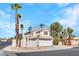 Charming two-story home featuring a tile roof, an attached garage, and well-manicured landscaping with mature palm trees at 125 Firecreek Cir, Las Vegas, NV 89107